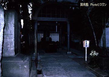 鼠小僧の墓が中央奥に見える。右斜め前の立て札には「鼠小僧之墓」と書いてある。